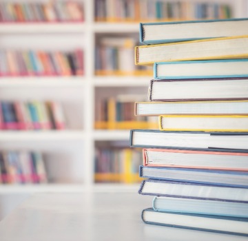 a pile of books on a table in a library